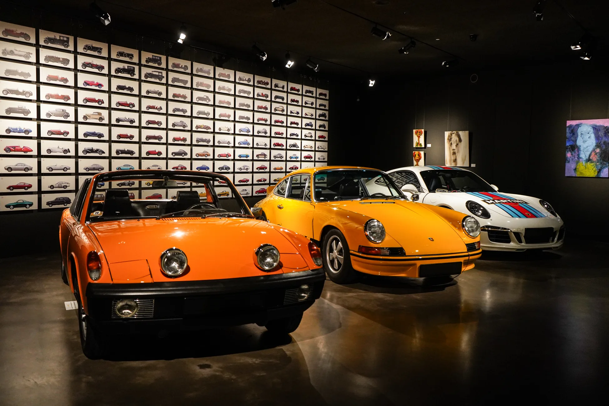 Porsche-Klassiker im Showroom vor einer Wand voller Modellautos