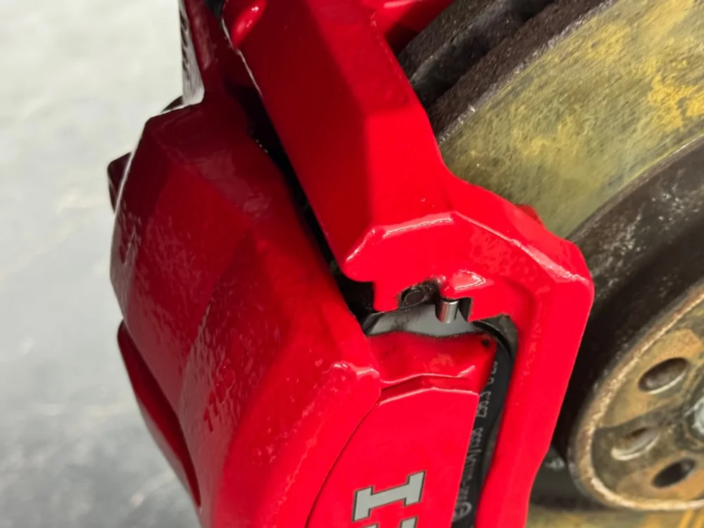 Roter GTI-Bremssattel nach dem Trockeneisstrahlen, wieder in kräftigem Rot