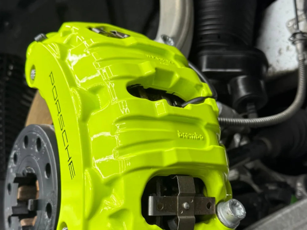 Giftgrüner Porsche-Bremssattel nach dem Trockeneisstrahlen