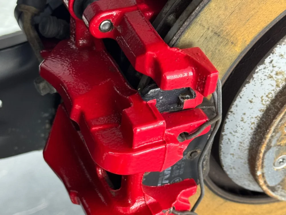 Roter Bremssattel mit Bremsscheibe nach dem Trockeneisstrahlen