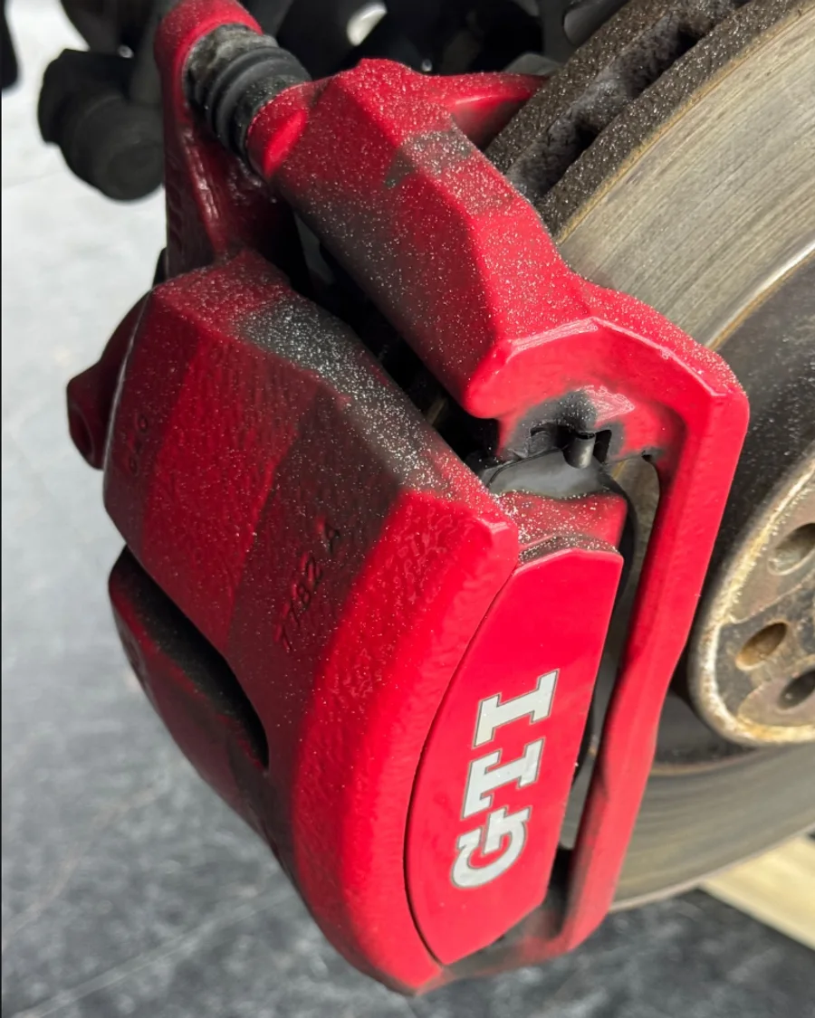 Roter GTI-Bremssattel vor und nach dem Trockeneisstrahlen — vorher