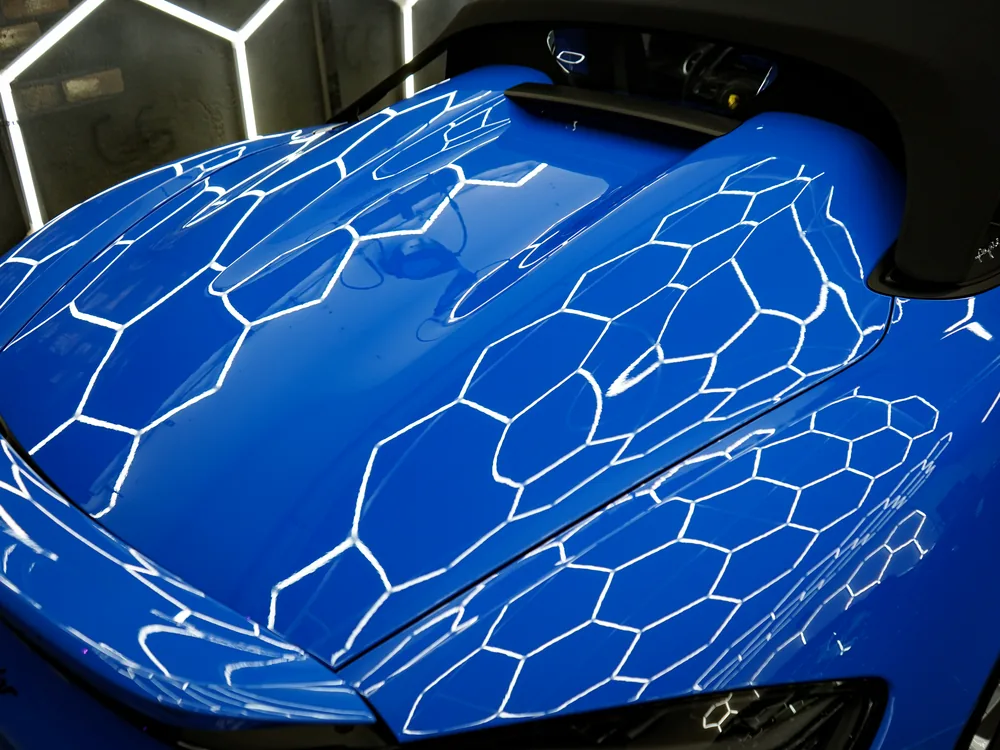 Fronthaube des Porsche 718 Spyder mit Spiegelungen der Hex-LED-Decke
