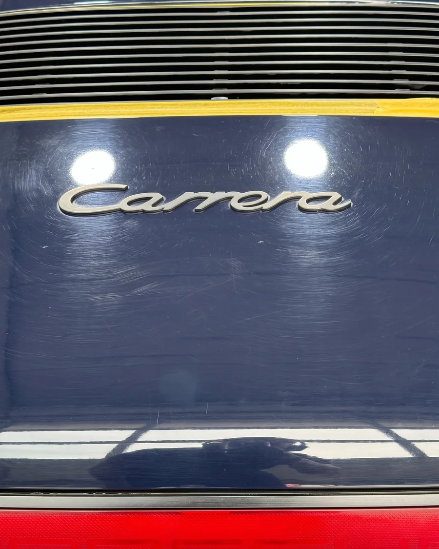 Heckdeckel eines blauen Porsche Carrera vor und nach der Politur — vorher